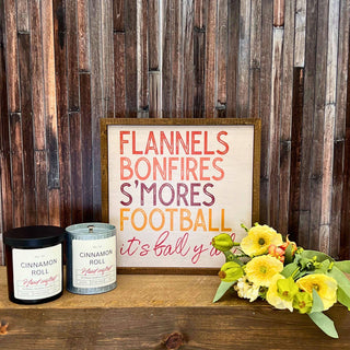 fall-themed decorative sign and two candles